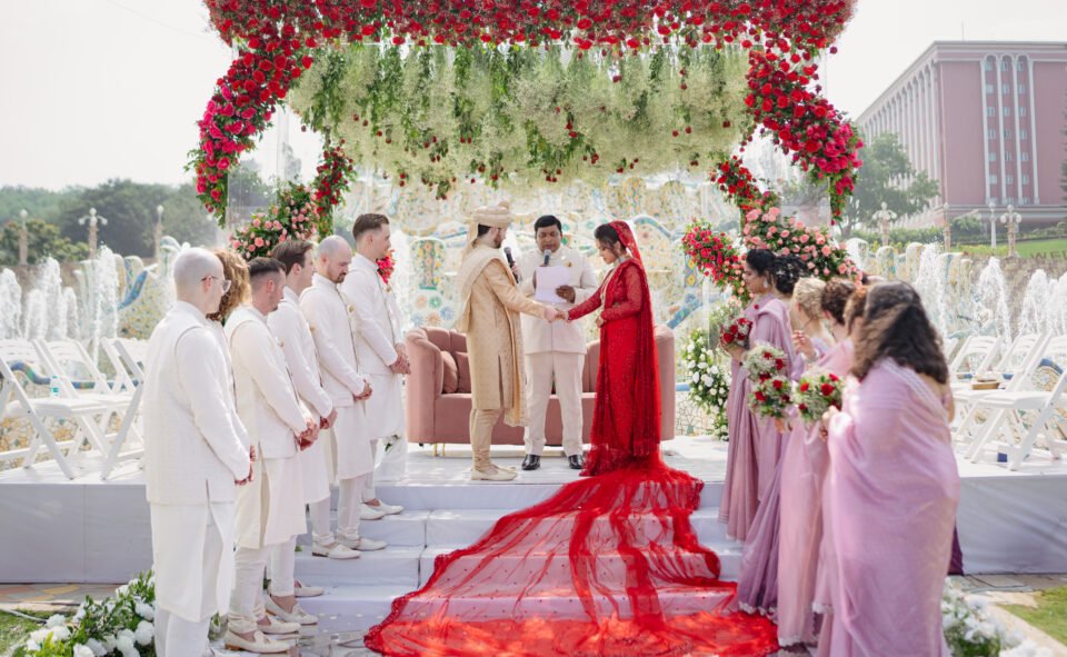 Wedding ceremony with red floral mandap at Ramoji Film City venue