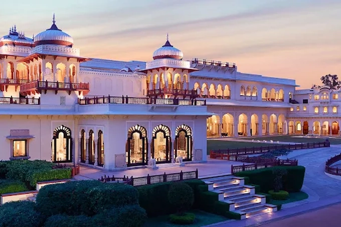 Rambagh Palace Jaipur wedding venue illuminated at dusk with manicured gardens