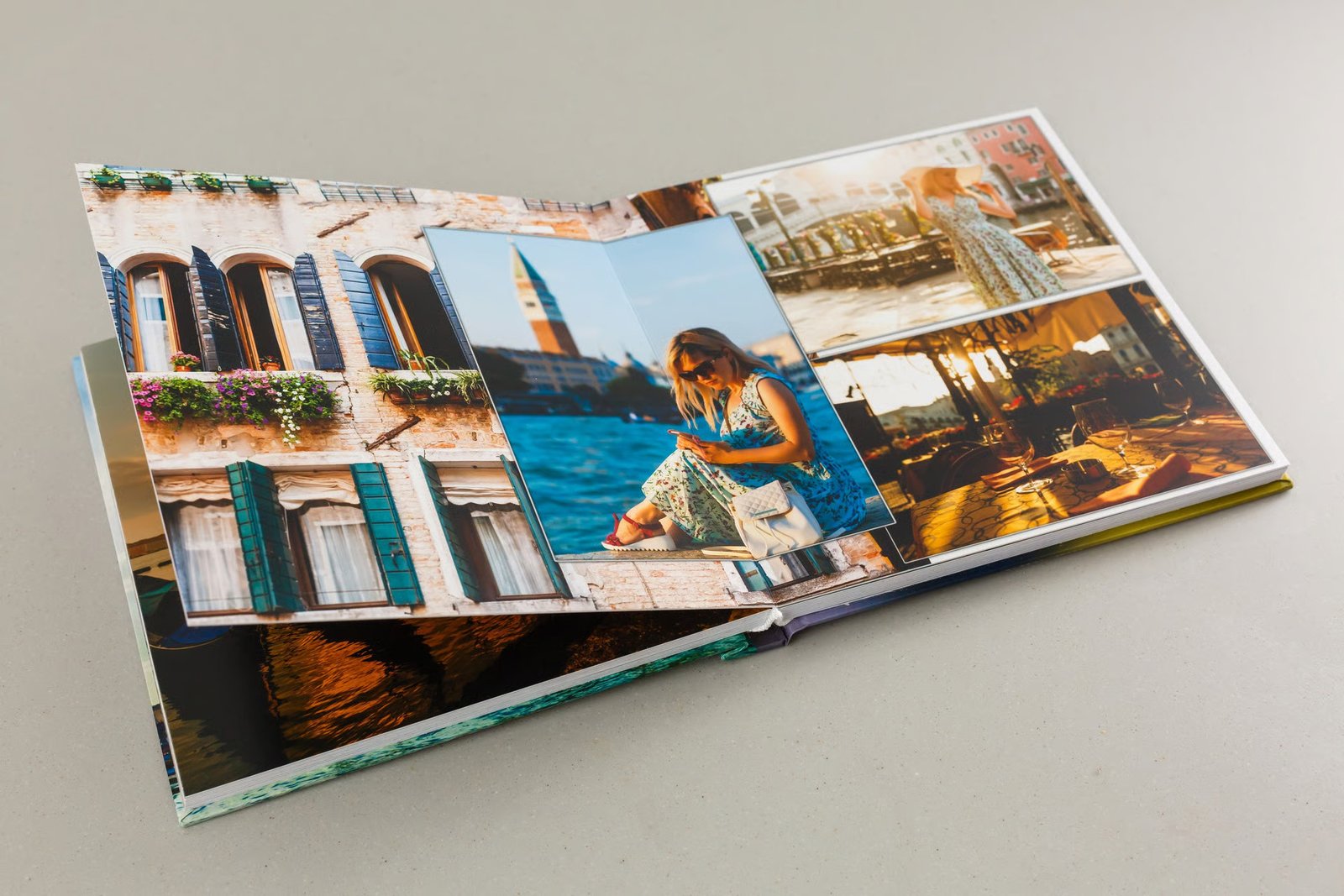 Open printed photo album displaying photographs from a canal-side city, showing spread layout and print quality