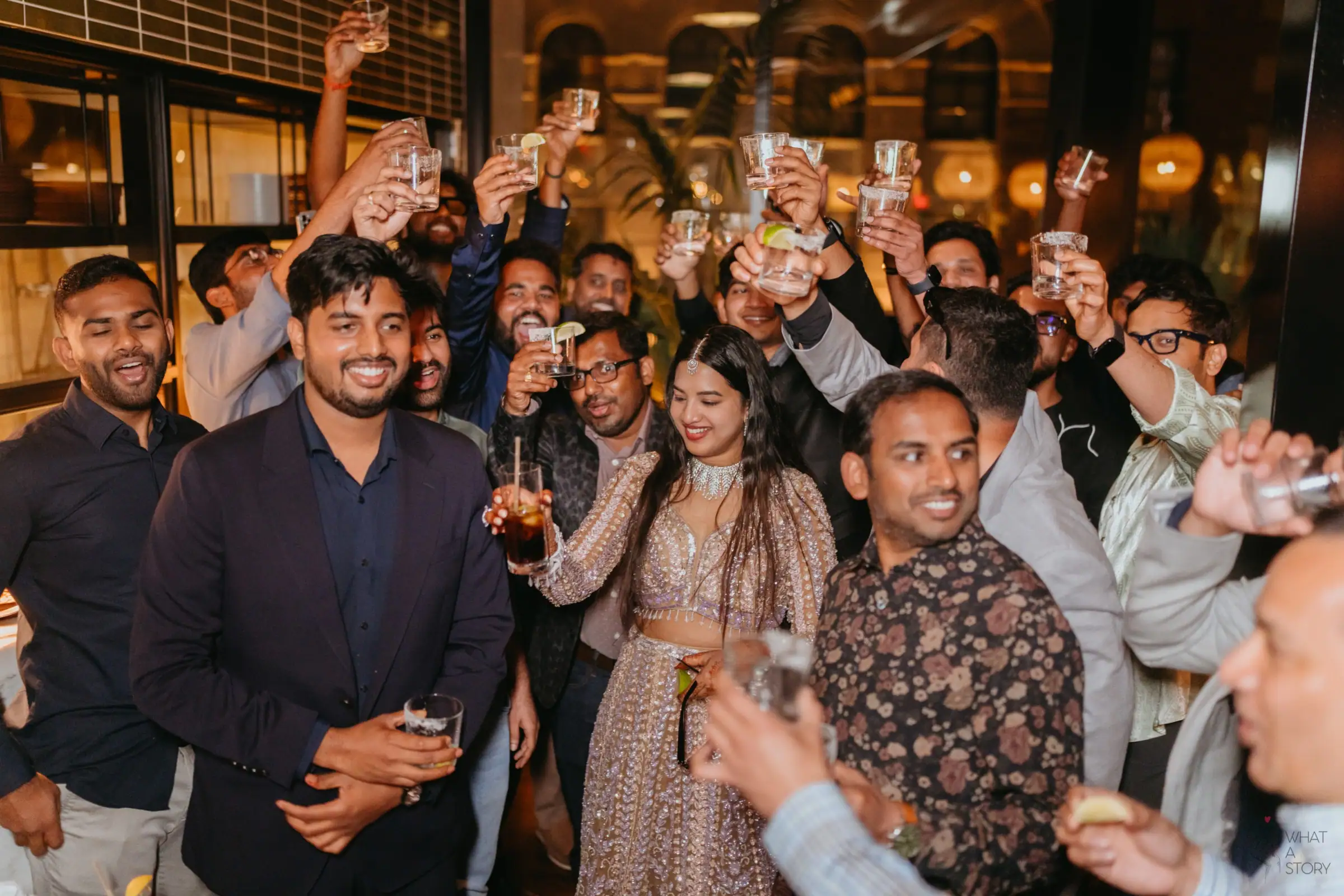 The bride raising a glass surrounded by friends at the cocktail party
